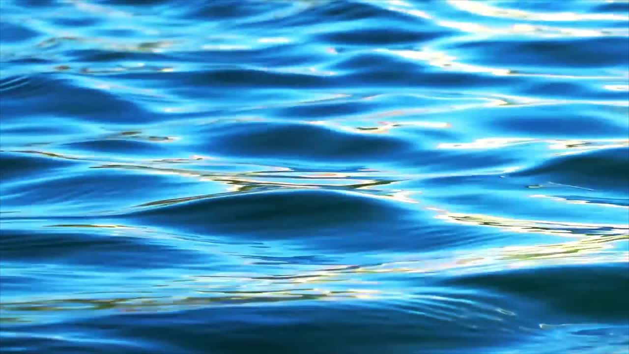 Increspature serene di acqua blu con riflesso scintillante del sole