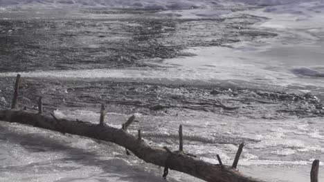 water flows through a partially frozen creek in canada