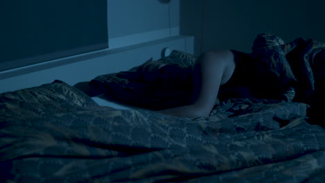 mujer colocando su mano en el lado vacío de la cama y quedándose dormida