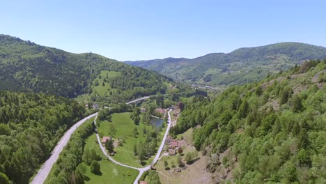 a drone shot over a road with a driving car in alsace, france