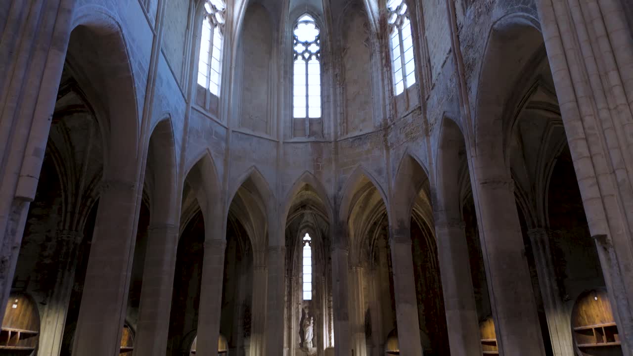 slow establishing shot within a French abbey with wine caskets