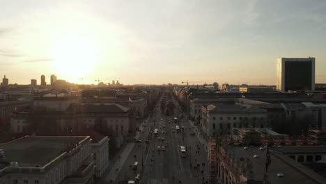 Aéreo:-Vuelo-Panorámico-Bajo-A-Través-De-La-Concurrida-Calle-Berlín,-Alemania-Hacia-La-Puerta-De-Brandenburgo-En-La-Hermosa-Luz-Dorada-Del-Atardecer