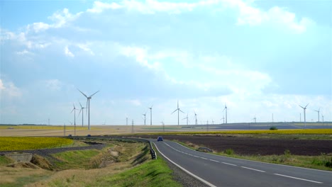 zoom in scene. wind turbines, highway and cultivated land