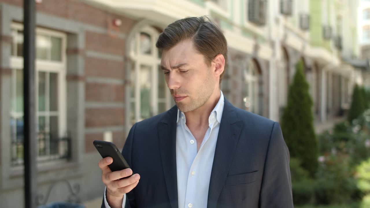 길거리에서 메시지를 입력하는 클로즈업 사업가. 길거리에서 스마트폰을 사용하는 남자