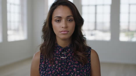 close up portrait of attractive young hispanic woman looking serious pensive at camera wearing beautiful floral blouse