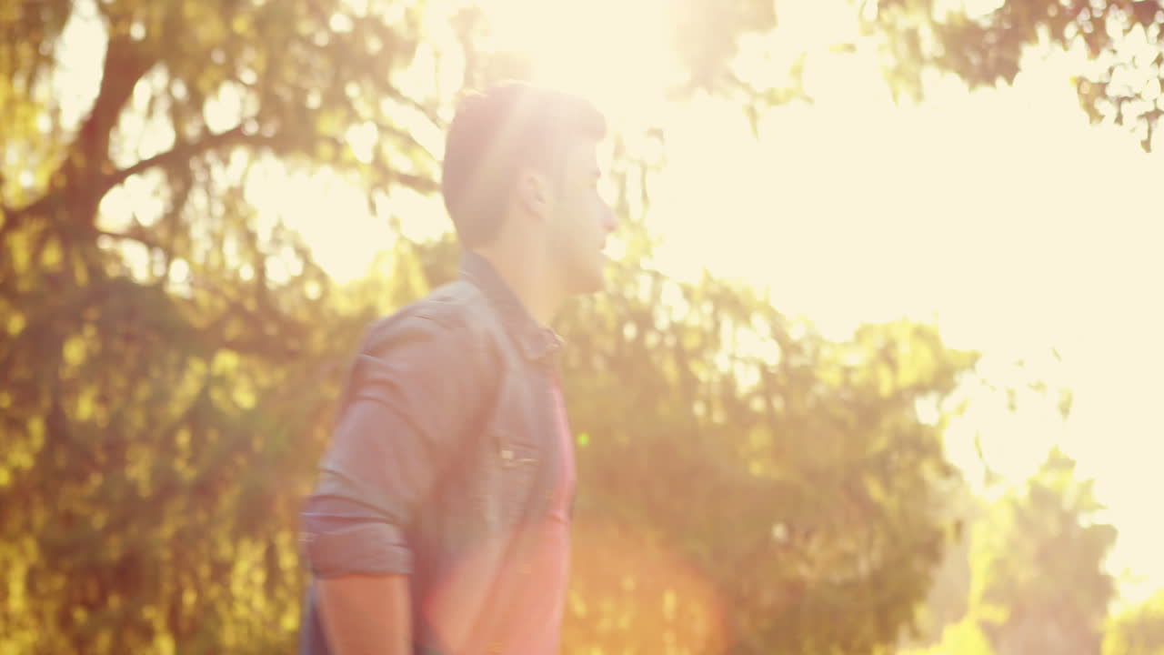 красивый мужчина чихает в парке.