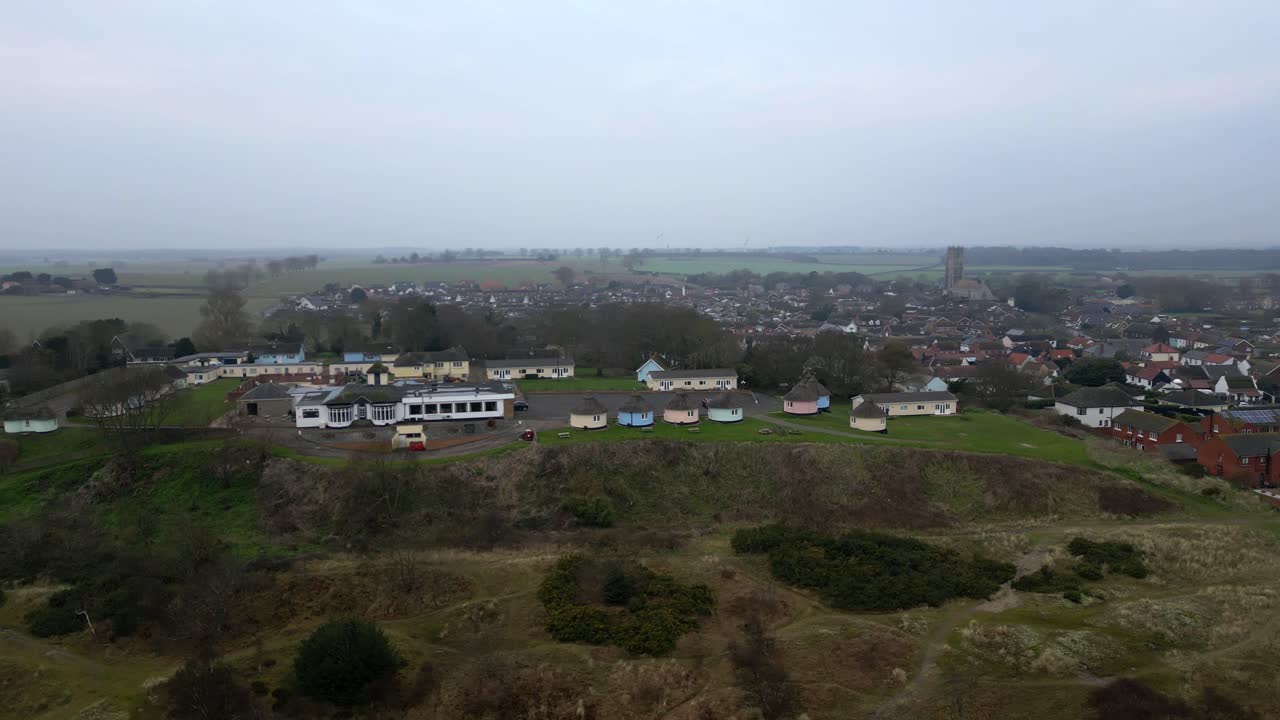 Drone parallax shot showing Hermanus huts and village layers in motion