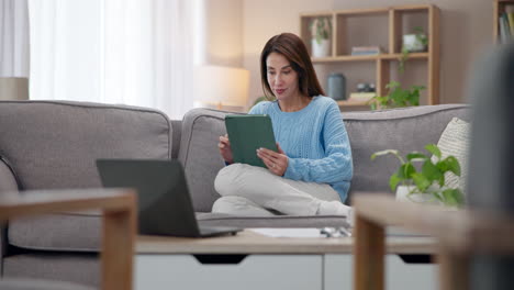 mujer relajándose en el sofá usando una tableta