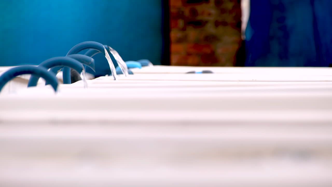 Sea water flowing into bubbling white fibreglass tanks and commercial aquafarm