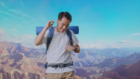 asian male hiker with mountaineering backpack enjoy dancing while traveling at the top of mountain