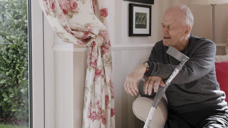 elderly man with crutches indoors