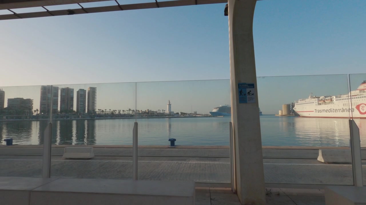 Modern Mediterranean port waterfront promenade with cruise ship at harbor