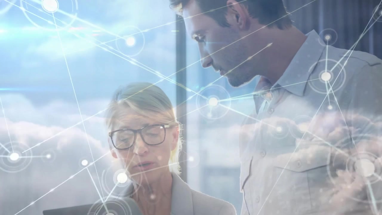 Businesswoman tapping tablet screen and pointing data to peer in office, illustrating cloud network
