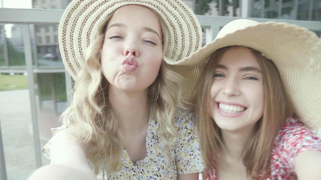 두 명의 행복한 친구들이 셀피를 찍고 있습니다.