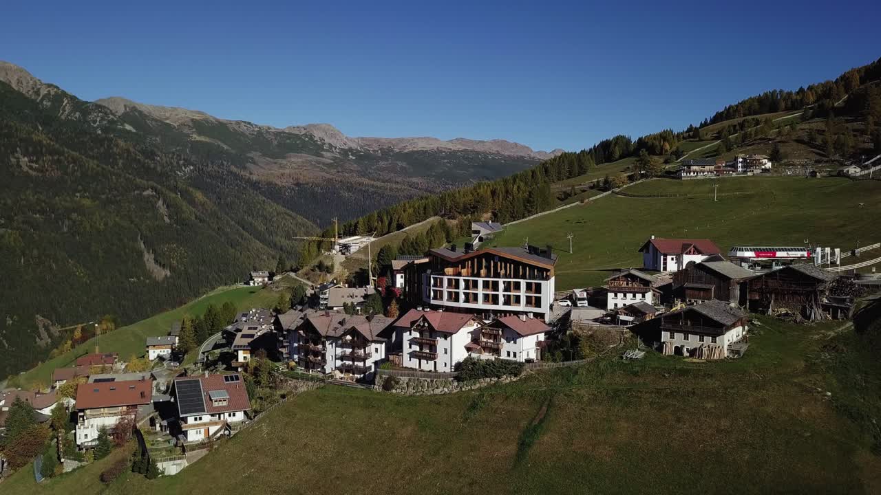Mountain hotel on a hill with houses and road and valley