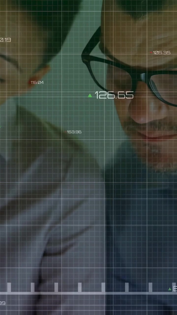 Video verticale: Analista finanziario uomo e donna che si chinano per valutare l'aggiornamento dei dati in tempo reale con un grafico HUD.