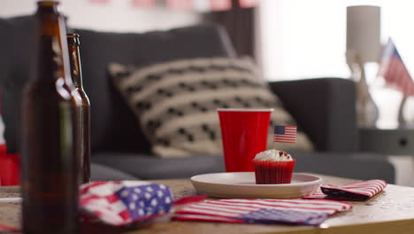 close up of cupcakes with american stars and stripes flags and bottles of beer at party celebrating 4th july independence day 2