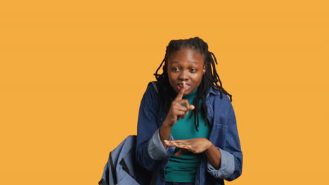 Stern-woman-doing-shushing-hand-gesturing,-studio-background