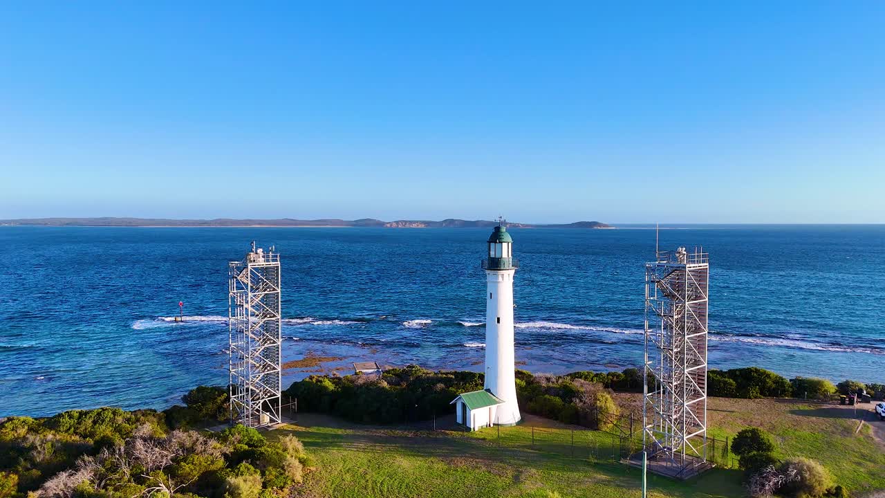 Aerial footage of Queenscliff Lighthouse on Bellarine Peninsula, showcasing coastal scenery and vibrant blue ocean under clear skies