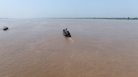 un automóvil asegurado a una balsa hecha a mano para el transporte a través del río benue por la ciudad de ibi, nigeria - seguimiento aéreo