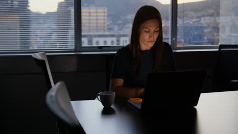 Front-view-of-attentive-young-Caucasian-female-executive-working-on-laptop-n-modern-office-4k