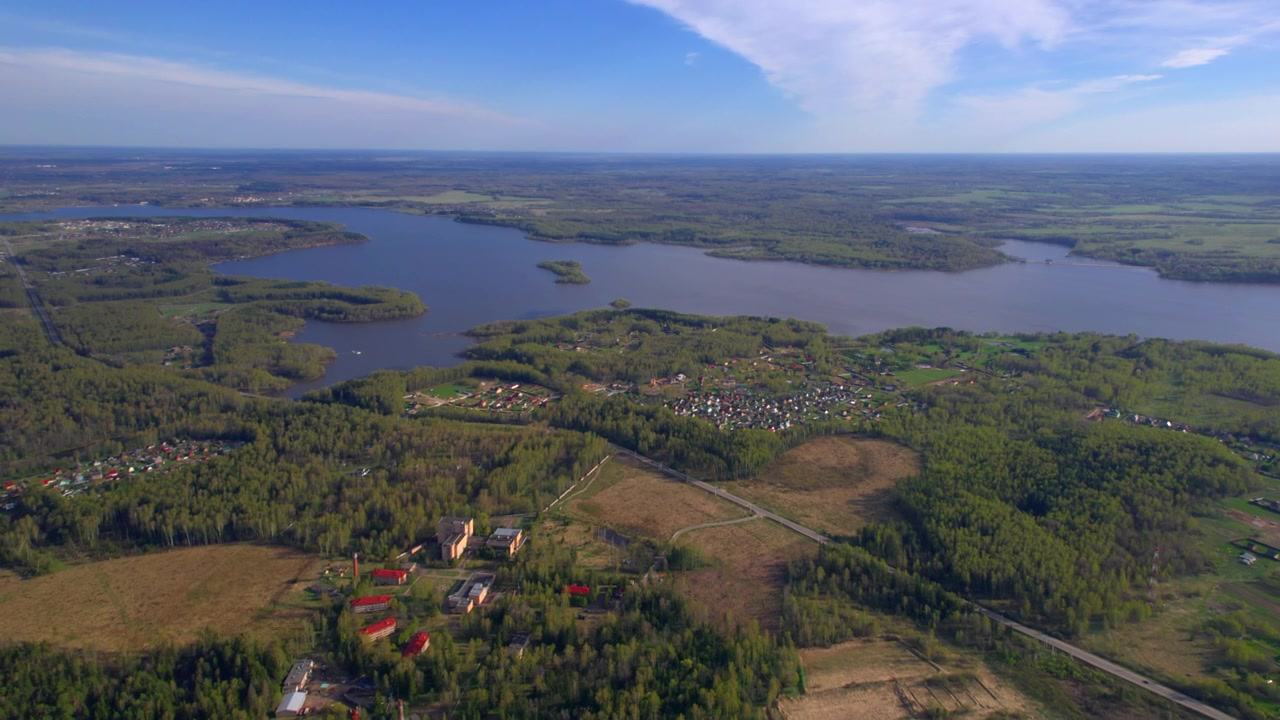 Hoog dronepanorama van een merenlandschap met dorpskernen, velden, bos en een blauwe lentelucht, ideaal voor plattelandsreizen, natuurbezit en landelijke taferelen