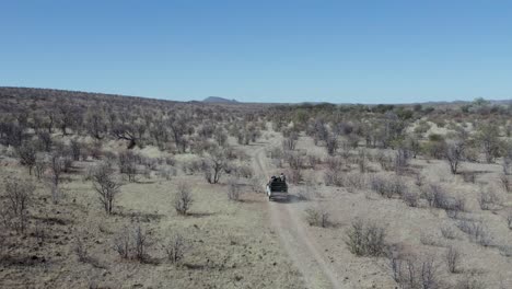 Vista-Aérea-Camión-Safari-Africano-Conduciendo-A-Través-De-La-Reserva-De-Caza,-Namibia