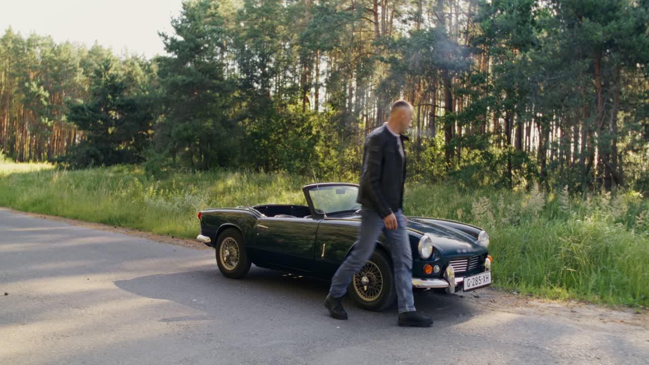 Man with a Classic Convertible Car in a Forest