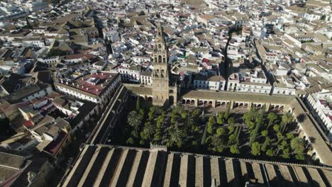 patio de los naranjos, iconic garden in cordoba cathedral with bell tower, torre del campanario, aerial orbiting