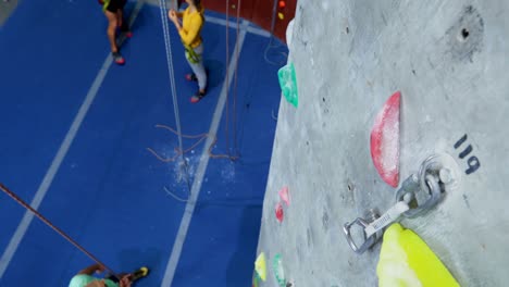 men and woman practicing rock climbing in fitness studio 4k