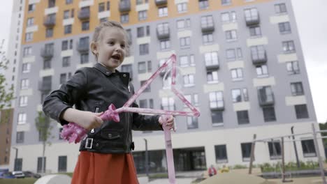 niña jugando con burbujas fuera del edificio de apartamentos