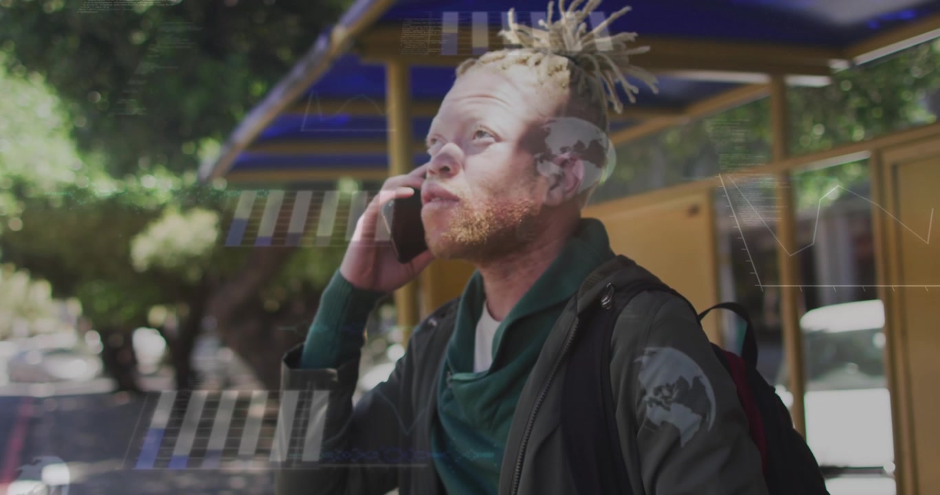 Animation von Grafiken, Globen, Karte über einem afroamerikanischen Mann mit Albinismus, der am Handy spricht.