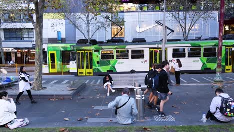 personas caminando cerca de un tranvía en movimiento