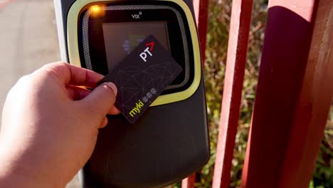 person tapping myki card on ticket machine