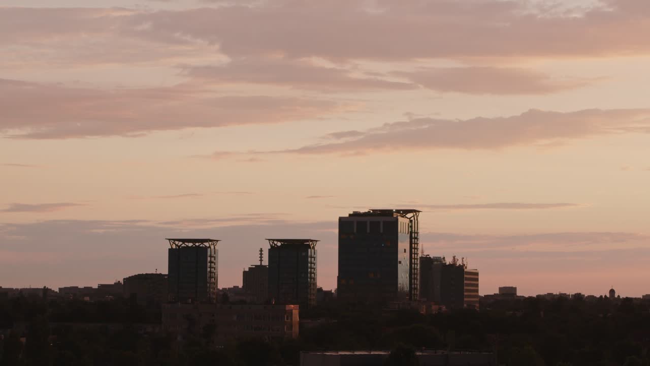 Paisaje urbano con timelapse de atardecer anaranjado.