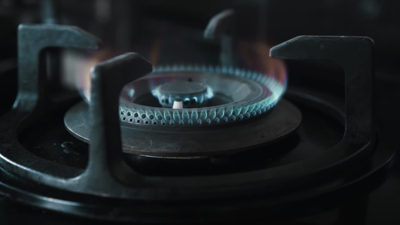 부에서 파란색과 빨간색으로 불타는 불꽃이 있는 검은색 가스 스토브의 비디오