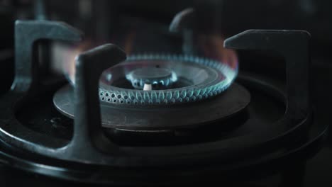 video of a black gas stove with blue and red burning flame in the kitchen