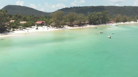 shallow cristal clear blue water of saracen bay beach in koh rong sanloem, cambodia - aerial fly-over shot