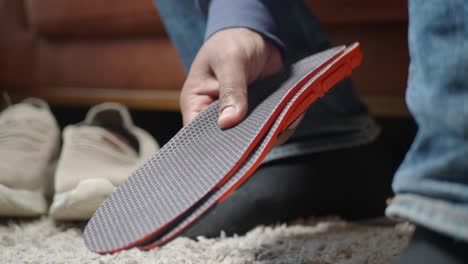 man holding insoles for shoes