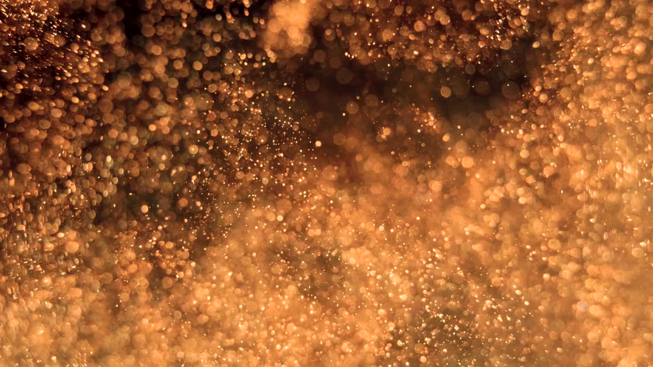 Elegant, detailed, and golden particles flow with shallow depth of field underwater