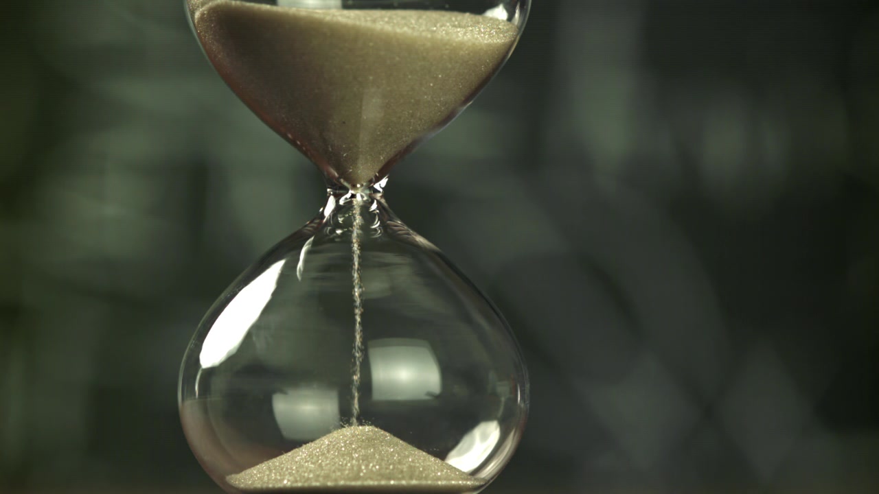 Sand Flowing Through a Classic Hourglass, Symbolizing Passing Time
