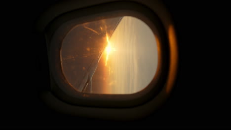 vertical video of an airplane window with a view of golden sunlight