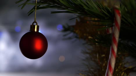 Red-Christmas-bauble-on-tree-against-window-close-up-shot