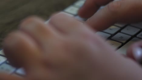 man types on a wireless keyboard extreme close up with copy space