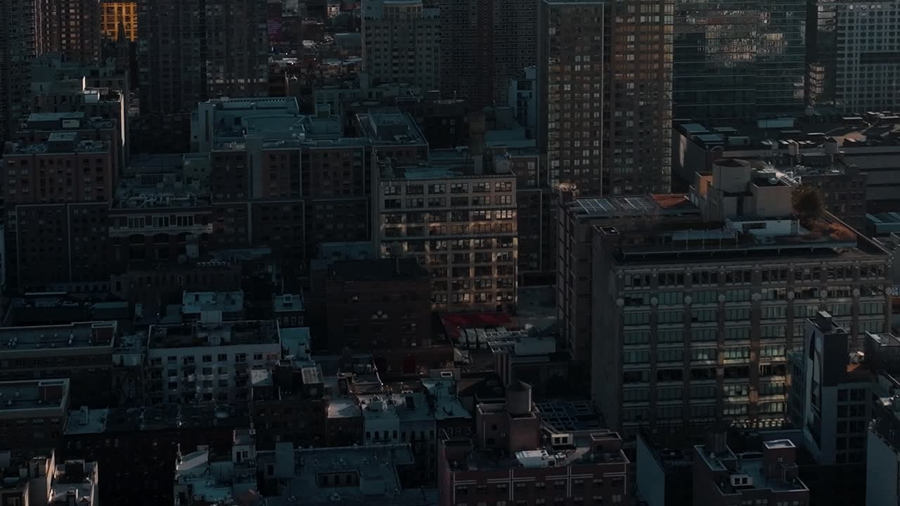 夕暮れ時のニューヨークの街並み。建物や灯りが見えます。