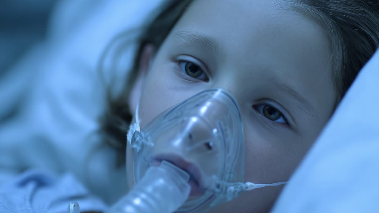 Un Bambino Vulnerabile Sottoposto a Cure Mediche, che Lotta con Problemi Respiratori, Mostra l'Importanza della Compassione e del Supporto Durante i Momenti Difficili in un Ambiente Ospedaliero.