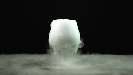 cognac glass with the effect of dry ice at black background - cognac glass with the effect of dry ice on black background at studio, chemical reaction with smoke on dark surface
