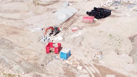 vehículo excavadora de excavación que prepara la vista aérea del tubo de hormigón en el sitio de construcción del desarrollo de viviendas, paso elevado inclinado lentamente hacia abajo