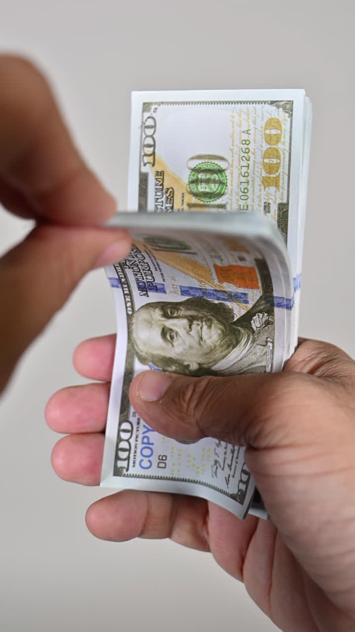 Man flips through counterfeit hundred-dollar bills, Fake money