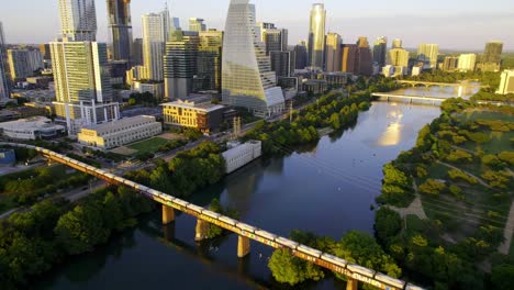 Vista-Aérea-De-Un-Largo-Tren-Que-Llega-A-Austin,-Texas,-Soleada-Tarde-De-Verano-En-Estados-Unidos---Inclinación,-Disparo-De-Drones